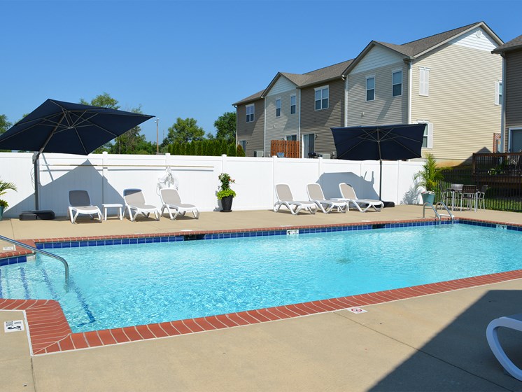 Outdoor pool with lounge chair seating and umbrellas